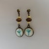 Détail des puces d’oreilles pendantes avec perles en bois