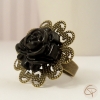 bague avec ffleur noire sur un support en bronze