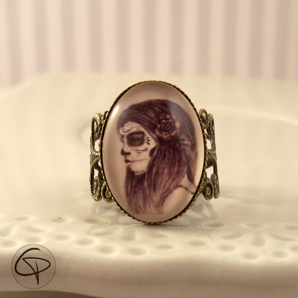 bague fantaisie avec un dessin de catrina dans un médaillon