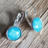 boucles d'oreilles argentées chat origami fond bleu émeraude