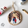 Boule pour sapin illustrée d'un couple marchant dans la neige